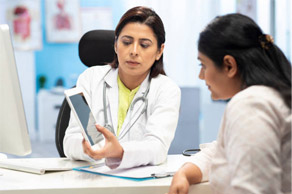 A Doctor Explaining On A Tab To The Patient